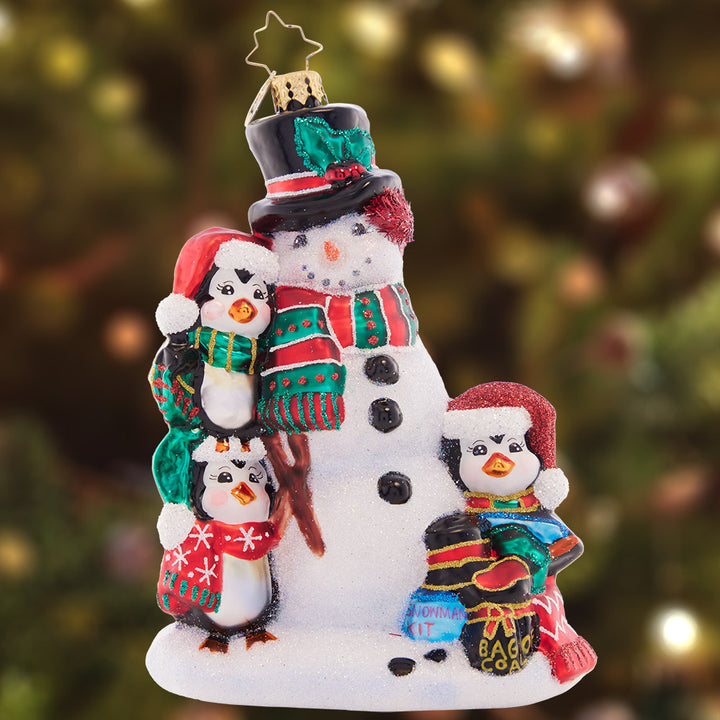 Ornament Descripion - Building Friends in Cold Places: A playful penguin trio is here to build the best snowman ever. They'll make the world come alive to share Christmas magic far and wide.