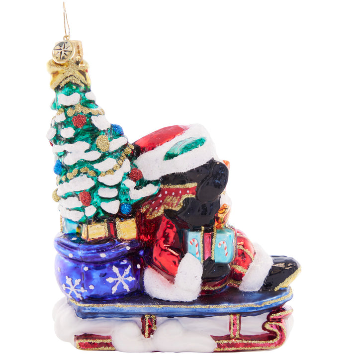 Side View 2 of 2 - Ornament Description - Christmas Getaway: Perfectly prepared with a trimmed tree, a sack of presents, and his trusty penguin pal, Santa zooms by in his speedy sled. He's got everything he needs for a cheer-filled Christmas!