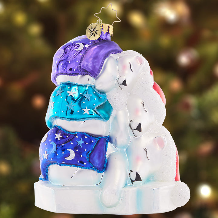Ornament Description - Piled High Polar Bears: Snuggled under star-speckled blankets, this trio of polar bears are sleeping soundly as they await the excitement of Christmas morning.