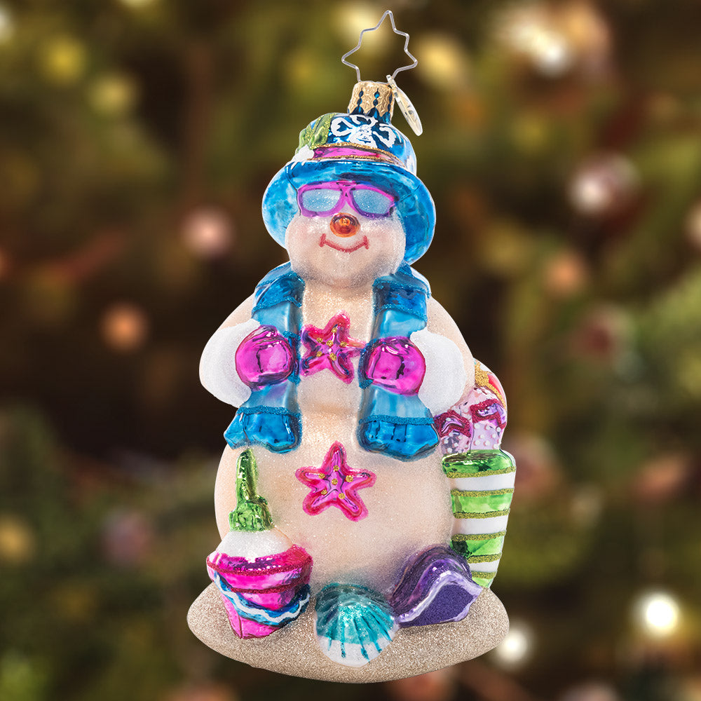 Ornament Description - Beach Day Snow Friend: Basking in the sunshine, this sand-colored Snowman is happy to have a break from the cold winter weather! He's ready for the perfect beach day with a pail and shovel for sandcastle building.