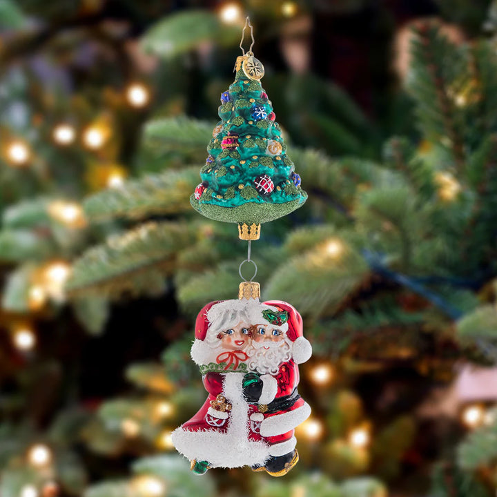 Ornament Description - Meet Me Under the Tree: Mr. and Mrs. Claus sure do make a magnificent couple! These Christmas cuties dance together under a trimmed tree. Where's the mistletoe?