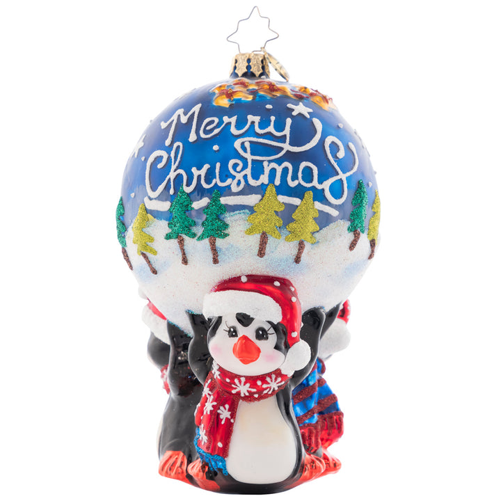 Ornament Description - A Lotta Help From My Friends: These penguins know, teamwork makes the dream work! Three flightless friends work together to hold up a beautiful ornament round, decorated with a snowy scene of Santa flying through the night sky.