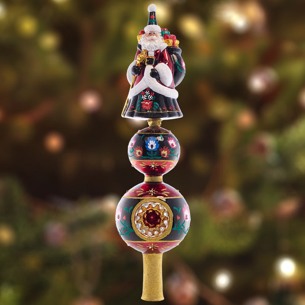 Finial Description - Festive Folk Art Santa Finial: Our 2022 Designer's Choice ornament is back on top of the tree! Enjoy this beloved European Christmas folk art fairytale finial with a one-of-a-kind festive design.