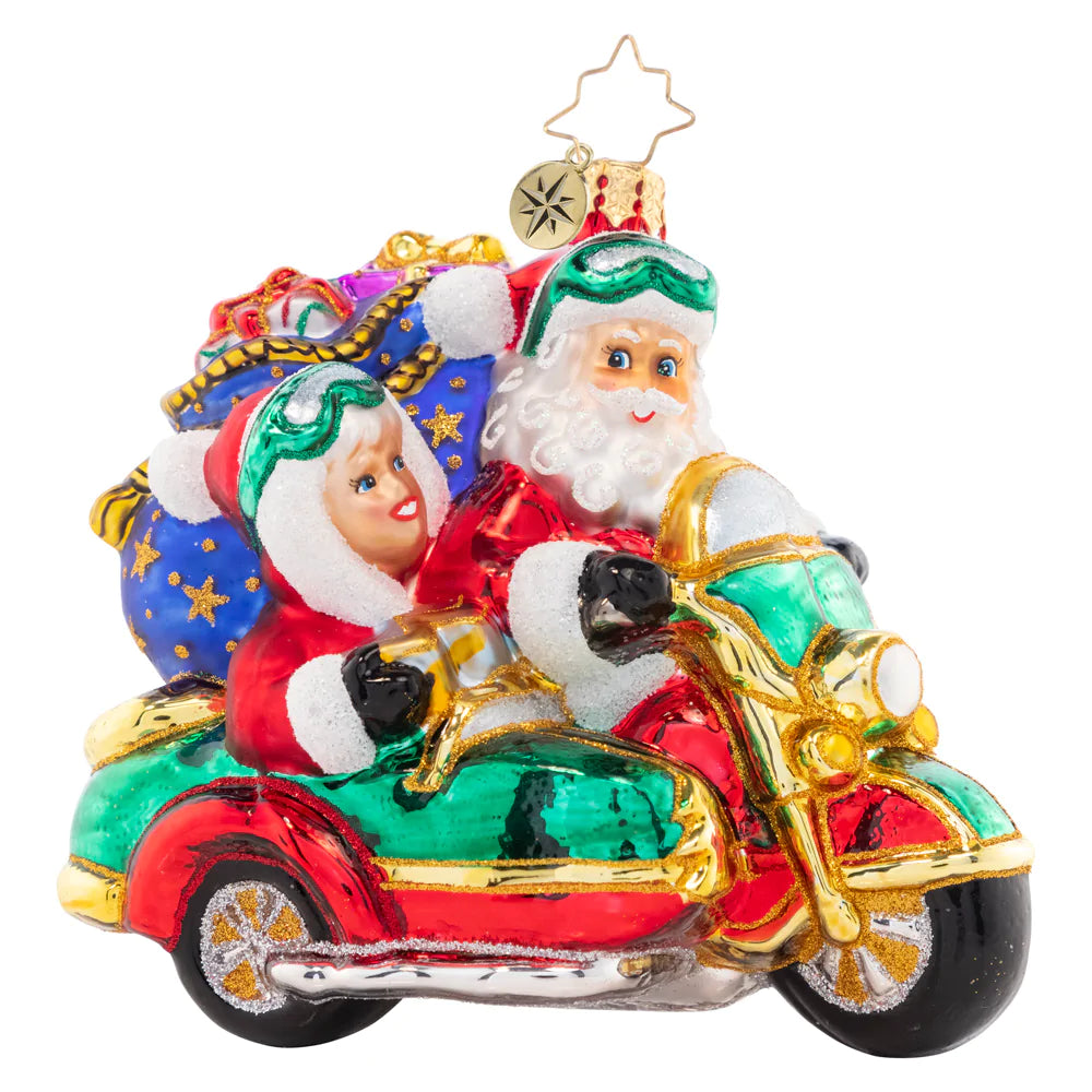 Front - Ornament Description - Santa's Sidecar Sidekick: The Clauses are dressed alike and going for a ride on Santa's Christmas motorbike. It was time to give the reindeer a break from all their delivery hoof aches.