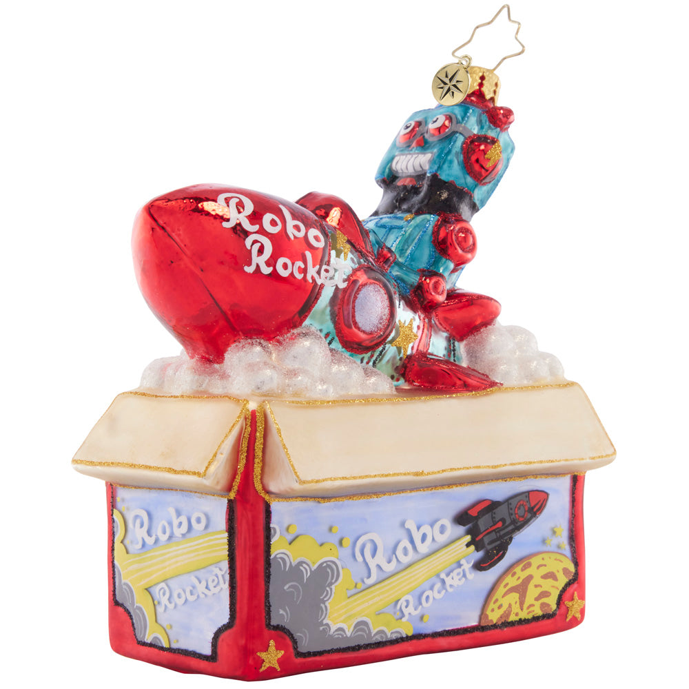 Front-Side View - Ornament Description - Robo Rocket Rides Again: Bursting from the box, this red robo-rocket toy is just begging to be played with on Christmas morning! This ornament evokes nostalgic memories of the of childhood holiday gifts.
