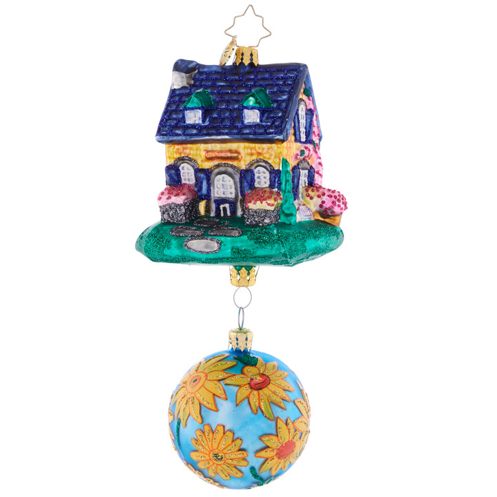Front - Ornament Description - Countryside Cottage: A vibrant flower-adorned blue round accompanies this colorful and happy-looking house. Welcome home holiday memories with this joyful piece!