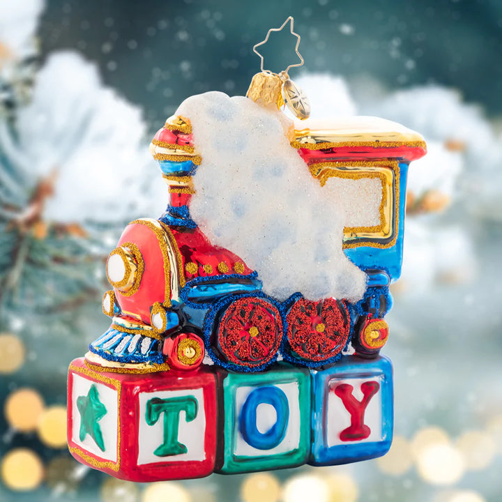 Ornament Description - Choo Choo Cheer: This little locomotive is perched atop colorful wood blocks, making the perfect Christmas gift for any toy-loving tot.
