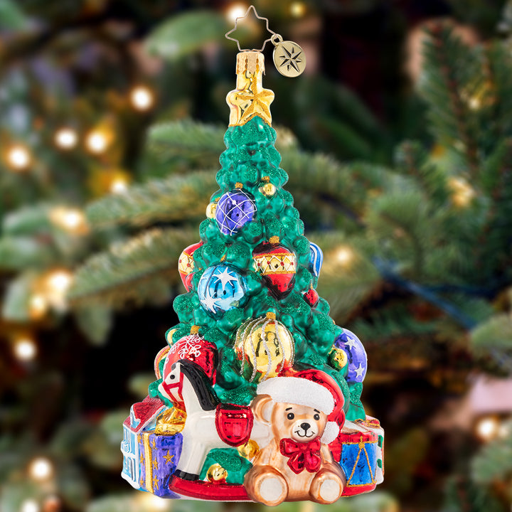 Ornament Description - Tastefully Trimmed Tree: A tree lined with toys fills a child's heart with great joy! With presents ready to delight this tree shines from the greatest of heights.