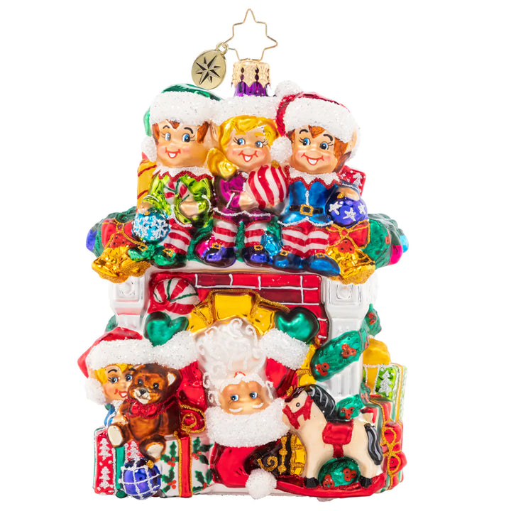 Front - Ornament Description - Fireplace High Jinks: Santa has all hands on deck this year – with a team of Christmas elves ready to help him spread cheer! This cozy fireplace is bedecked with gifts galore, making an adorable addition to your collection.