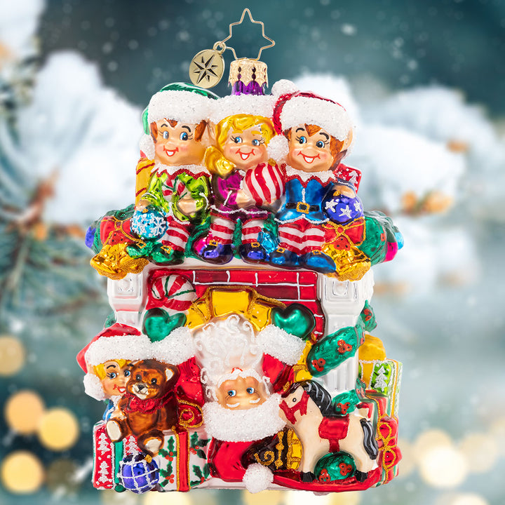 Ornament Description - Fireplace High Jinks: Santa has all hands on deck this year – with a team of Christmas elves ready to help him spread cheer! This cozy fireplace is bedecked with gifts galore, making an adorable addition to your collection.