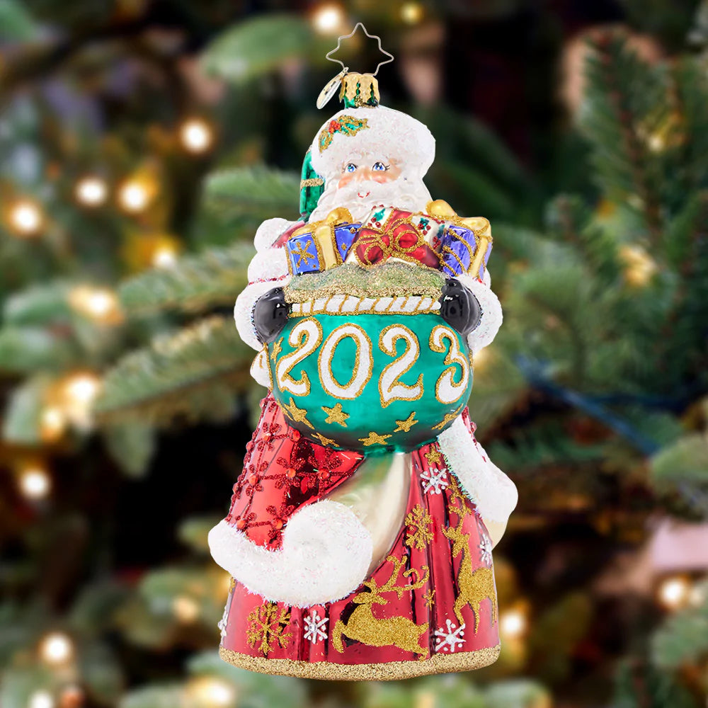 Ornament Description - New Year Nice List: St. Nick spreads kindness and cheer throughout the year. Stepping into 2023 with a crimson coat adorned with golden deer!
