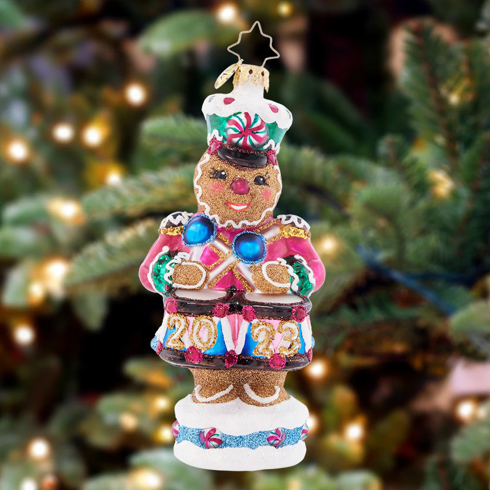 Ornament Description - Drumroll Please: A gingerbread guard gallantly protects the candy castle, ensuring that it outlasts hungry hands of good little girls and boys before Christmas day.