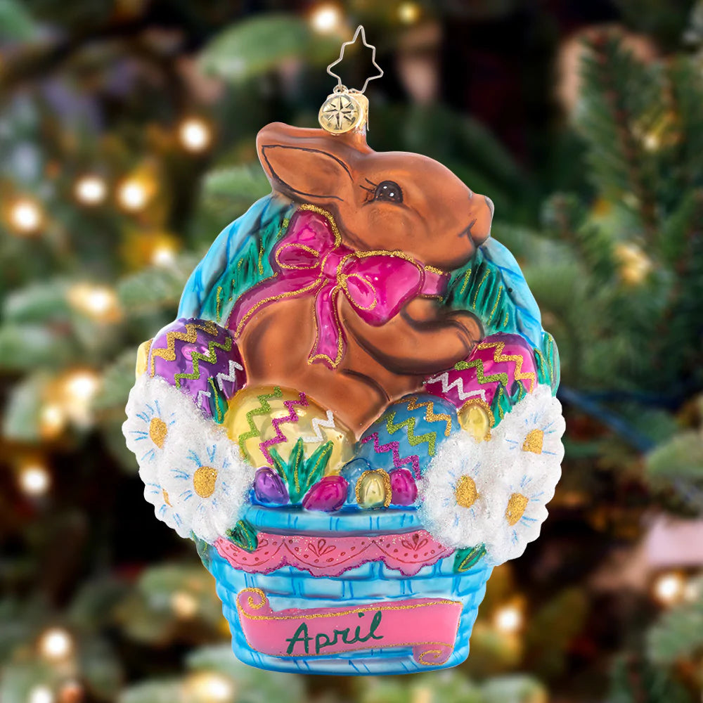 Ornament Description - Happy Easter: The fourth piece in our Ornament of the Month collection will have you hippity-hopping for joy! A blushing bunny has leapt into an Easter basket, joining the hunt for candy-filled eggs.