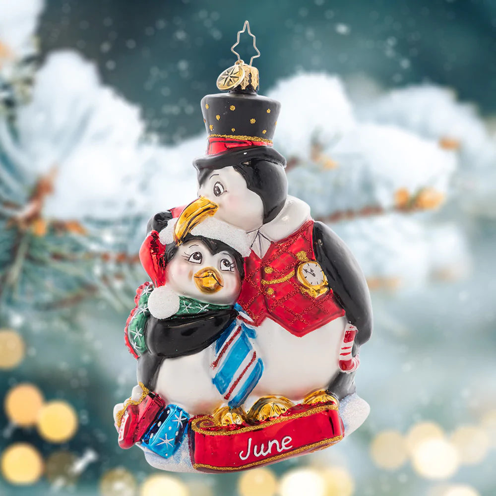 Ornament Description - Here's to the Dads: This dapper dad penguin gives his kiddo a playful peck as they celebrate a fun Father's Day. The sixth piece in our Ornament of the Month collection celebrates dad!