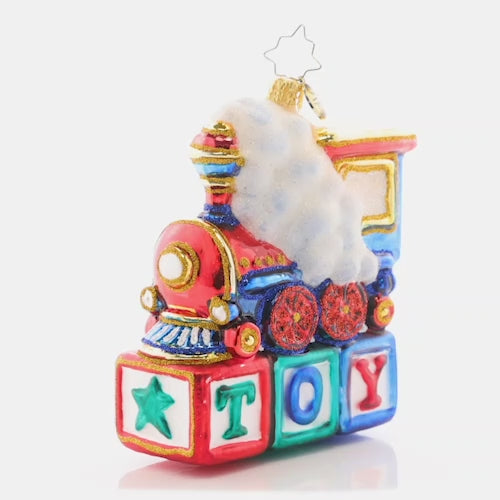 Video - Ornament Description - Choo Choo Cheer: This little locomotive is perched atop colorful wood blocks, making the perfect Christmas gift for any toy-loving tot.