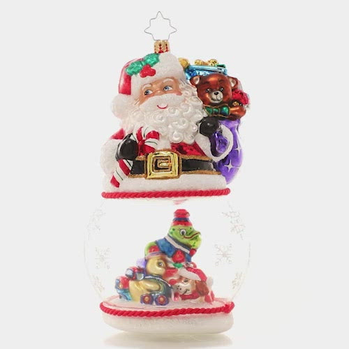 Video - Ornament Description - Santa's Magic Snow Globe: It's a wonderful time of the year for Santa Claus, who's looking even more jolly than usual! With his sack of surprises slung over his shoulder, he smiles over a pile of Christmas toys inside a swirling snow globe. This video shows the ornament spinning slowly. 