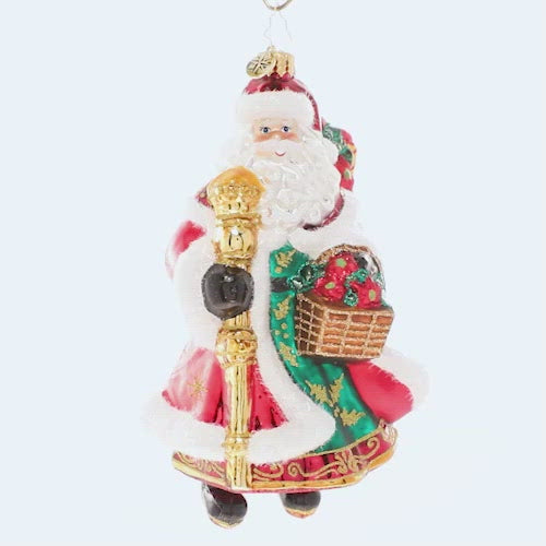 Video - Ornament Description - Festive Florals Santa: With a gift basket of Christmas poinsettias and decorated robes to match, Santa is heading to a fancy holiday party. His golden staff will help light the way through the snow. This video shows the ornament slowly spinning.