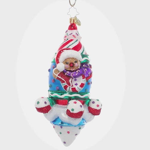 Video - Ornament Description - Tasts of Space: A super sweet rocket ship blasts into space piloted by a smiling gingerbread man. Good thing he's bundled up – it gets cold up there! This video shows the ornament spinning slowly. 