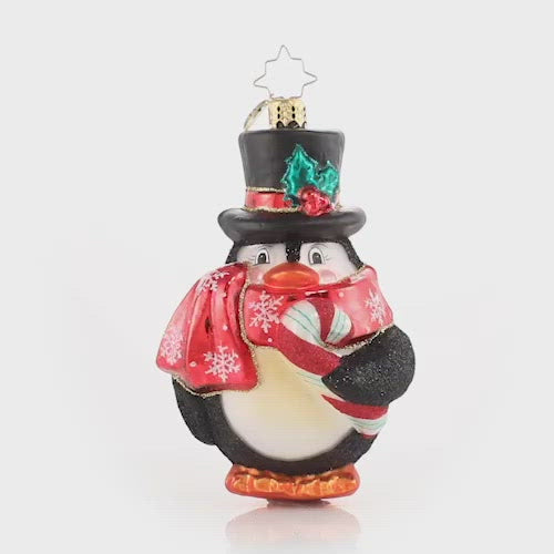Video - Ornament Description - Flightless Yet Fashionable: He may not be able to fly, but this bird sure has style! Mr. Penguin waddles into our hearts in his festive scarf and top hat, snacking on his favorite tasty treat!