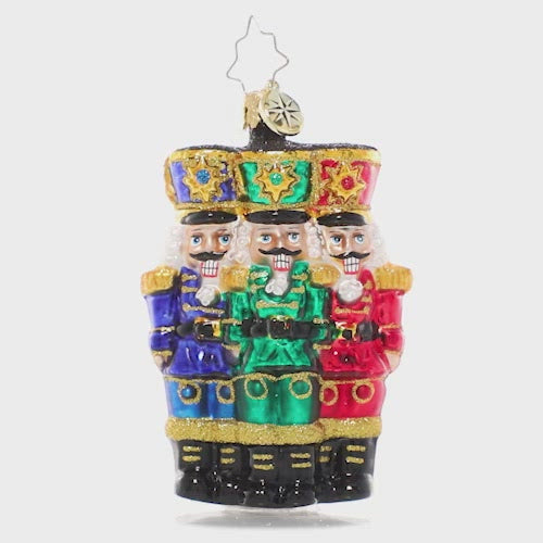 Video - Ornament Description - The Nut-Cracking Pack Gem: Thrice as nice! A trio of nutcracker soldiers stand together, grinning in royal uniforms of bright Christmas jewel tones. This video shows the ornament spinning slowly. 