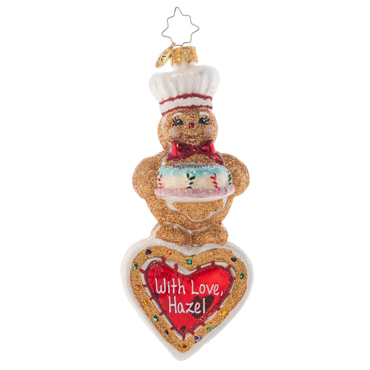Ornament Description - Sweet Heart Baker: Let this cuddly gingerbread fellow send your own personal greetings to friends and family! He'll make a wonderful impression with his ear-to-ear grin and a colorful cake baked with love. Note: Please allow approximately one month (on top of shipping time) for our elves to personalize your ornament.