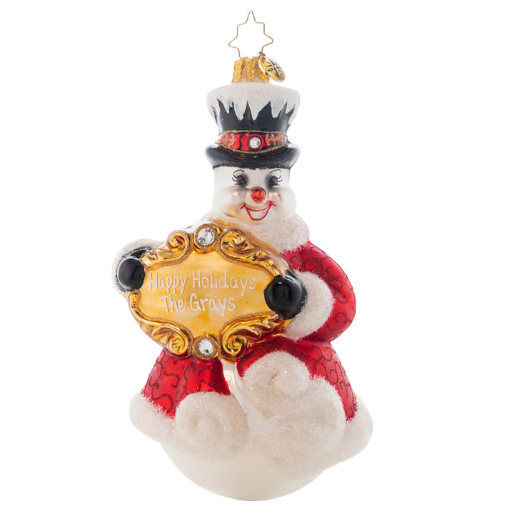 Ornament Description - Frosty Friend: This snowman knows that your own personal greeting is a true masterpiece! That's why he'll display it prominently in a bold, bejeweled frame. Note: Please allow approximately one month (on top of shipping time) for our elves to personalize your ornament.