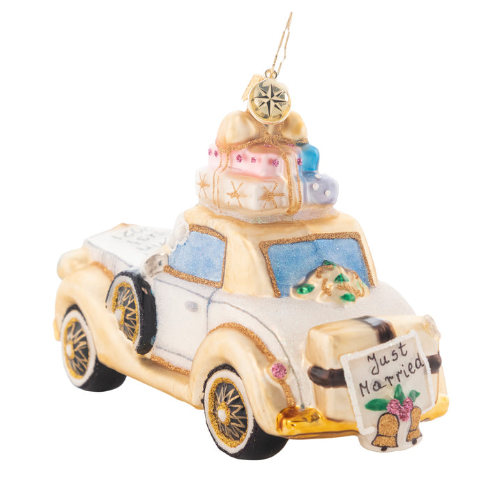 Back - Ornament Description - Wedding Bliss Chariot: The happy couple takes off after their wedding in this wedding bliss chariot! Their gifts stacked high atop the roof and their bags packed for a honeymoon of memories at the back, this loving couple is ready for their happily ever after! Note: Please allow approximately one week (on top of shipping time) for our elves to personalize your ornament.