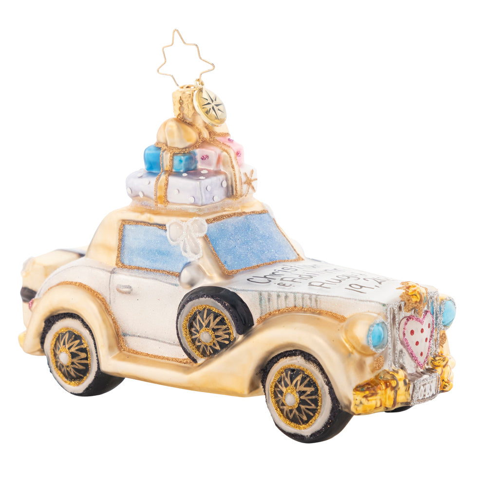 Front - Ornament Description - Wedding Bliss Chariot: The happy couple takes off after their wedding in this wedding bliss chariot! Their gifts stacked high atop the roof and their bags packed for a honeymoon of memories at the back, this loving couple is ready for their happily ever after! Note: Please allow approximately one week (on top of shipping time) for our elves to personalize your ornament.