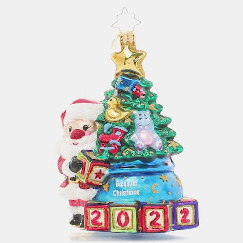 Video - Ornament Description - Extra Special Delivery: This adorable Santa has taken extra special care of the latest addition to his nice list – a new baby in the family! Celebrate their first Christmas with this darling ornament featuring a tiny tree decorated with special treasures to delight any little one. The video shows this ornament slowly spinning. 