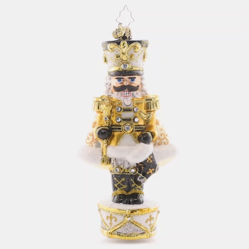 Video - Ornament Description - Golden Guardian: Gleaming and bold in white and gold, this Nutcracker is guarding the gift of Noel. Decorate your tree with this superbly stunning piece. This video shows the ornament slowly spinning. 