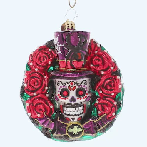 Video - Ornament Description - Spooky Skull Wreath: Celebrate spooky season with this gothic-inspired calavera wreath. A ring of blood-red roses encircles a trio of black bats and a grimacing sugar skull – all things that make Halloween so frightfully fun! This video shows the ornament spinning slowly. 