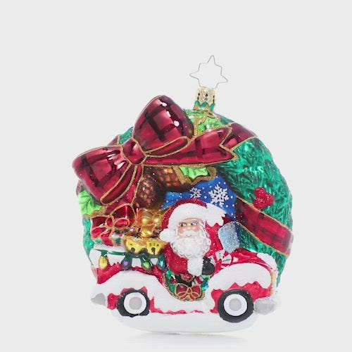 Video - Ornament Description - Rustic Christmas Wreath: A festive tartan bow is the perfect accent for this classic Christmas wreath ornament that features swirling snowflakes, bright holly berries and even the big man himself, Santa Claus! He's speeding through in his Christmas pickup with a truckload of last-minute deliveries. This video shows the ornament spinning slowly. 