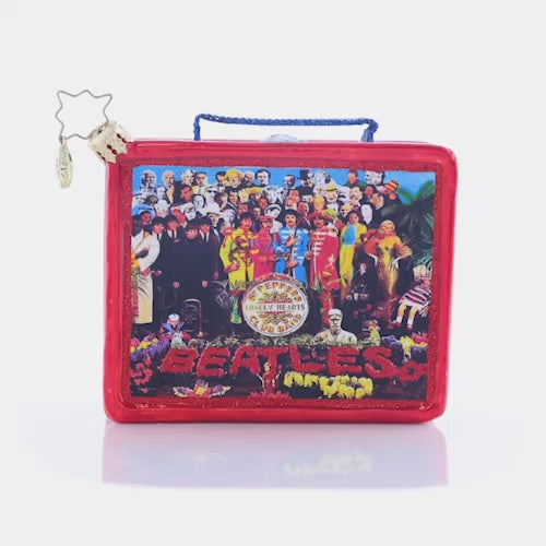 Video - Ornament Description - Sgt. Pepper Lunch: The hottest lunchbox in the school cafeteria! This replica of a collector's item is its own cherished piece! This ornament miraculously features the album art for the iconic Sgt Pepper's Lonely Hearts Club Band in all its stunning detail. This video shows the ornament spinning slowly. 