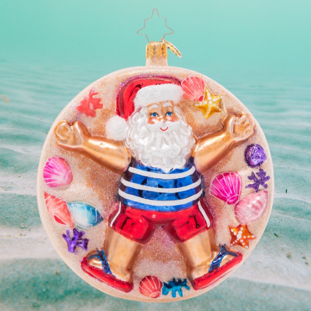 Ornament Description - Beach Cherub Claus: Santa has traded snow angels for sand angels! He's embracing his inner beach bum on a sunny vacation at the beach.