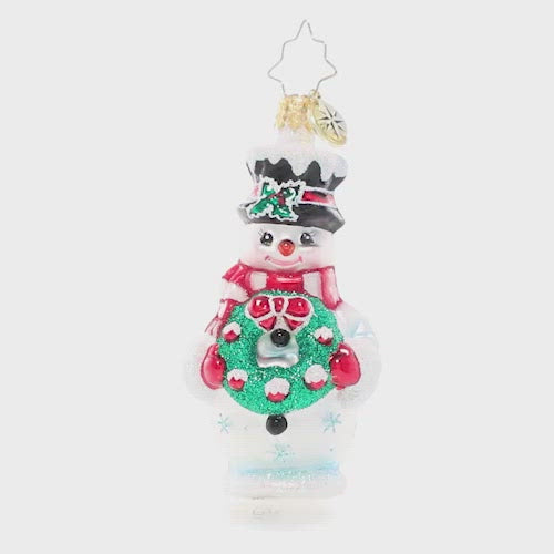 Video - Ornament Description - Darling Christmas Decorator Gem: This frosty snowman has been waiting all year long to deck the halls! He's fashioned his very own wreath and is excited to help his friends turn the town into a festive winter wonderland. The video shows the ornament slowly spinning. 
