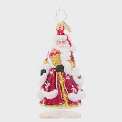 Video - Ornament Description - An En-deer-ing St. Nick Gem: Santa Claus looks extra festive in his ruby red robes decorated with glittering white flourishes. He carries a gleaming golden staff to help light his way through the cold winter's night.