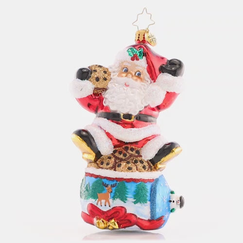 Video - Ornament Description - Santa's Snack Break: Delivering presents all around the world is hard work! Santa is taking a much-needed break atop a cookie jar decorated with a wintertime scene. This video shows the ornament spinning slowly,. 