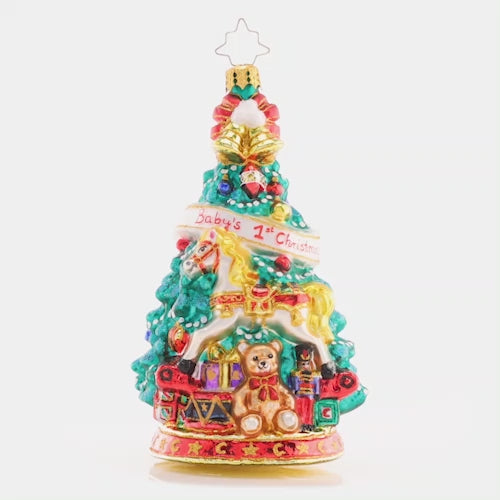 Video - Ornament Description - Tot's First Tree: Adorned with an adorable teddy bear and radiant rocking horse, this festive tree commemorates baby's first Christmas. This video shows the ornament spinning slowly. 