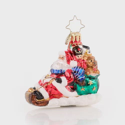 Video - Ornament Description - Timely Toboggan Delivery! Gem: Santa won't let a little thing like air traffic slow him down, so he's ditched the sleigh and taken to the slopes on his trusty toboggan instead. Look out below! This video shows the ornament spinning slowly. 