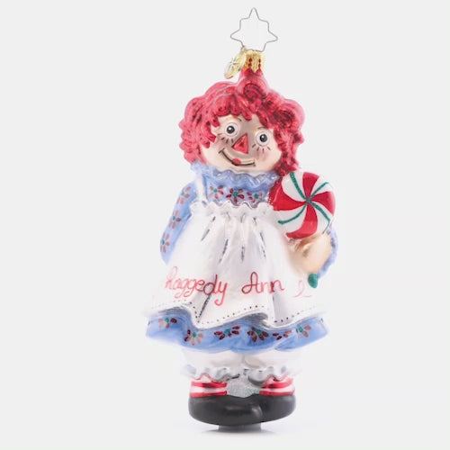 Video - Ornament Description - Raggedy Sweets: This timeless sweetie has her own sweets this Christmas. Share the love and childlike wonder this season with Raggedy Ann. She got all "dolled" up for you in her best holiday dress and apron! This video shows the ornament spinning slowly. 